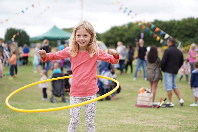 Image of child playing with a hula-hoop. 