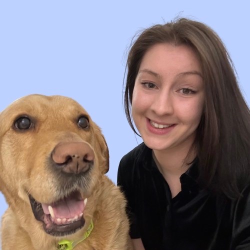 young employee smiling with her guide dog