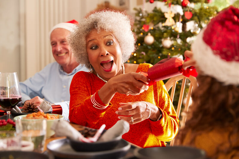 Lady pulling Christmas cracker at a dinner table