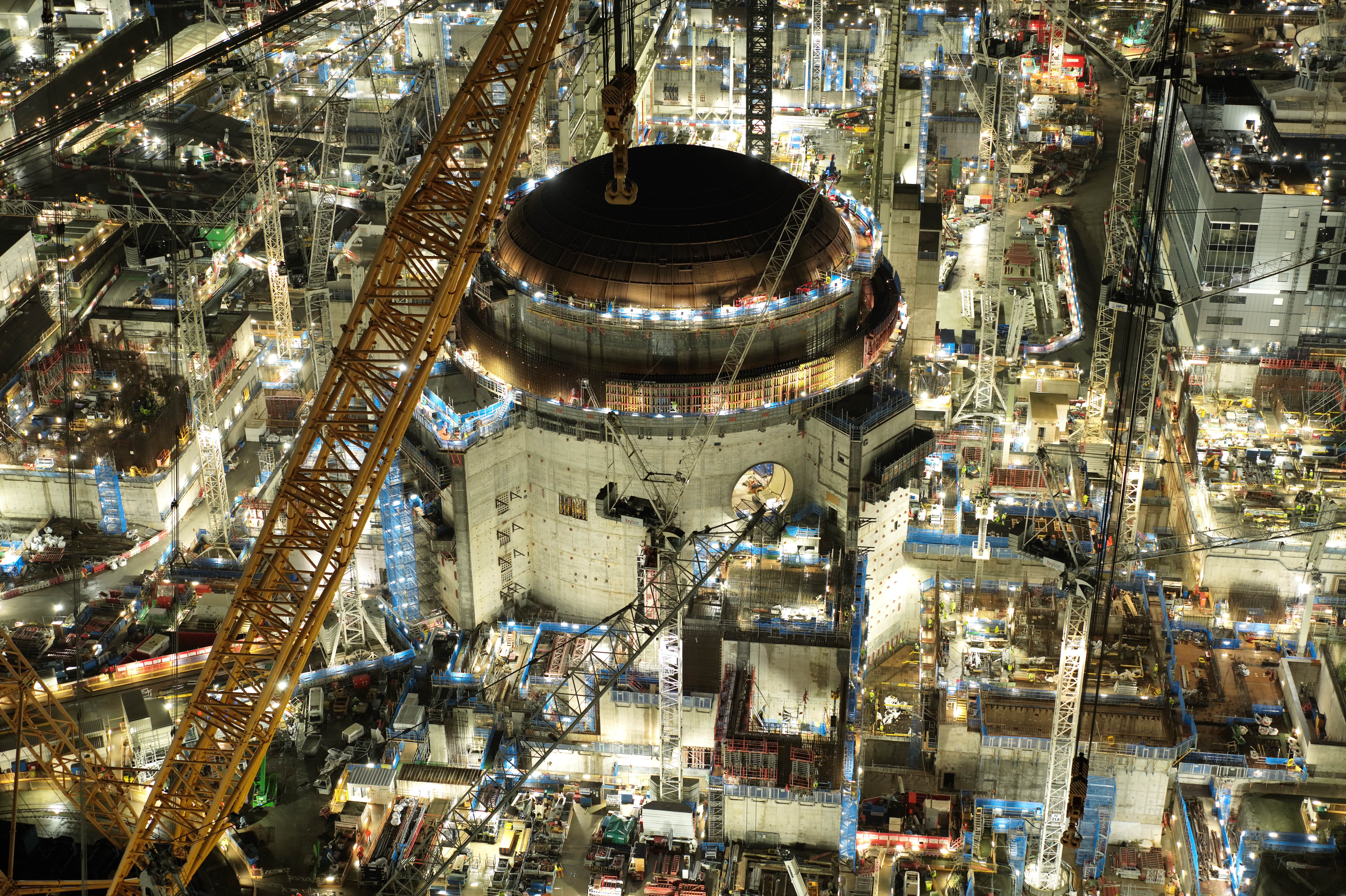 Some of the project’s most impressive milestones happen at night. In July, the world’s largest crane, Big Carl lifted the 245-tonne domed roof onto the second reactor building