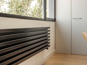 A modern, flat, horizontal designer radiator under a window