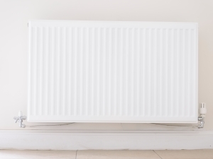 A white single panel radiator on a wall