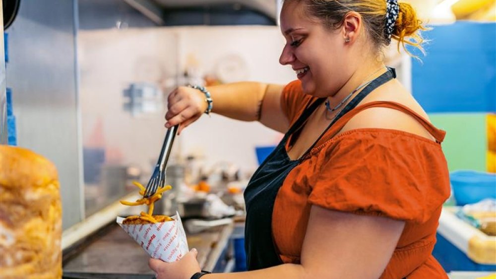 Woman creating cone of chips