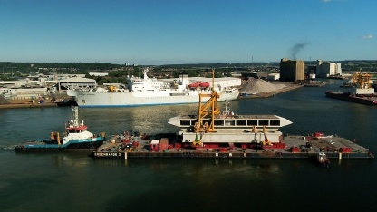 The barge breaks away from the dock, and is guided by towing boats to its next mooring spot