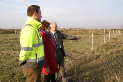Rob Starbuck, environmental compliance coordinator at Dungeness B, Christine Blythe, EDF Energy's biodiversity manager and John Bennett chief executive of Kent Wildlife Trust admiring the growth of wild carrot plants since the fencing has been put up