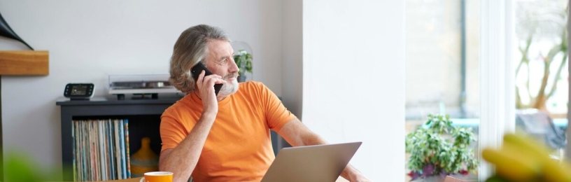 Man on phone next to laptop