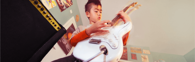 Young boy playing an electric guitar
