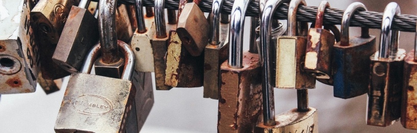 Metal pole holding lots of different sized and looking metal padlocks 