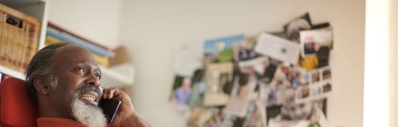 Man in orange jumper speaking on his mobile phone