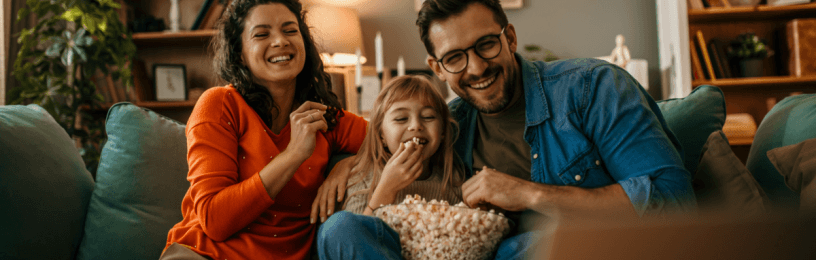 Family sitting on sofa with popcorn