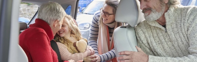 A family in an EV car playing with their child