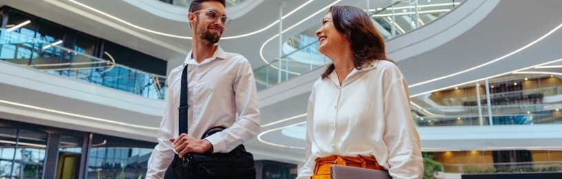 Two business people speaking and walking