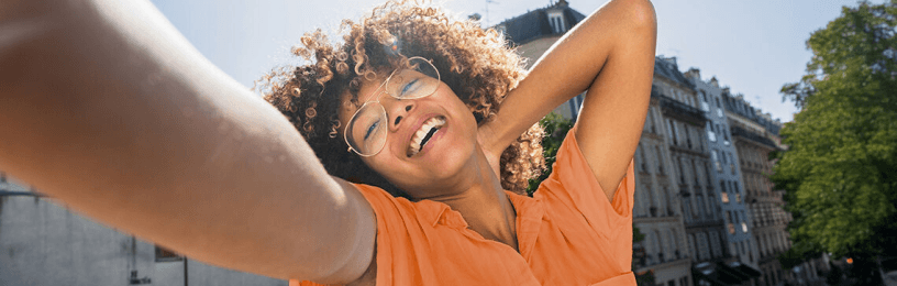 Happy woman on balcony in orange tee