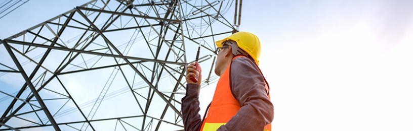 Engineer looking up at a electricity pylon