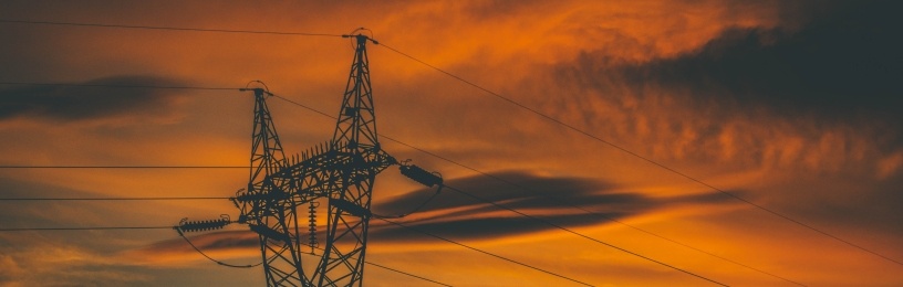 Electricity pylons against a sunset