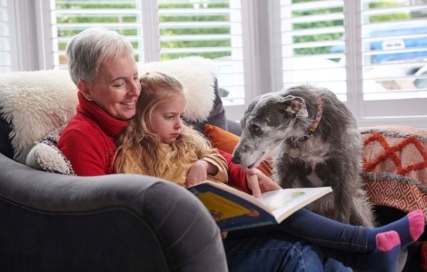 Family reading with dog on sofa