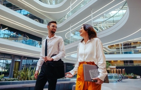 Two business people speaking and walking