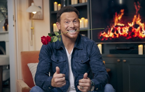Joe Swash poses with a rose in his mouth