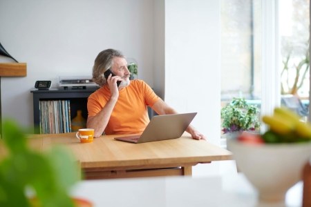 Man on phone next to laptop