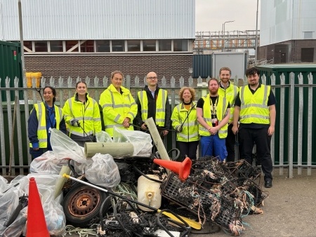 A group of staff from Torness power station with a large pile of rubbish collected from beaches near the power station during a volunteer beach clean