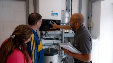 Installer showing customers how to use their air source heat pump system