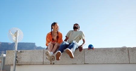 Two people sitting on a wall laughing