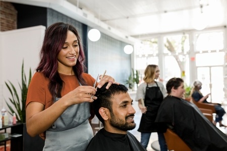 hairdressing salon with customer getting their hair cut, happy and smiling