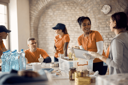 several volunteers in orange around a desk