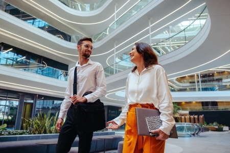 Two business people speaking and walking