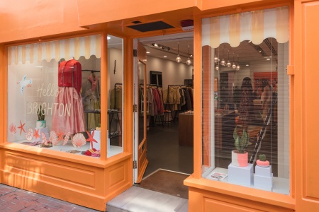 Orange shop in Brighton with clothes and pots in window
