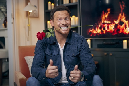 Joe Swash poses with a rose in his mouth