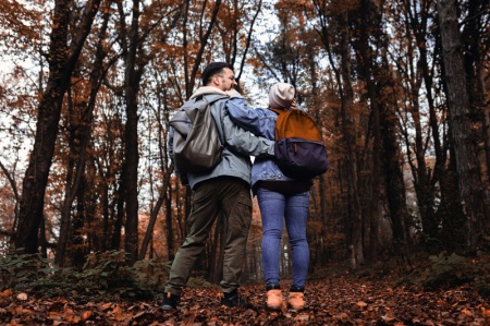 Couple with arms around each other in an autumnal wood 