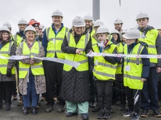 People at a ribbon cutting ceremony at a wind farm