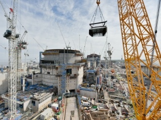 A giant ‘mega-lift’ underway in April. Steel reinforcement for a staircase is being craned into Unit 2 Reactor Building. Steel cages are fabricated and joined together in a satellite yard nearby, speeding up work and removing congestion from the workface. 