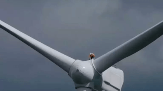 wind turbine engineer standing on turbine