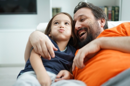 Father and daughter relaxing together on a sofa