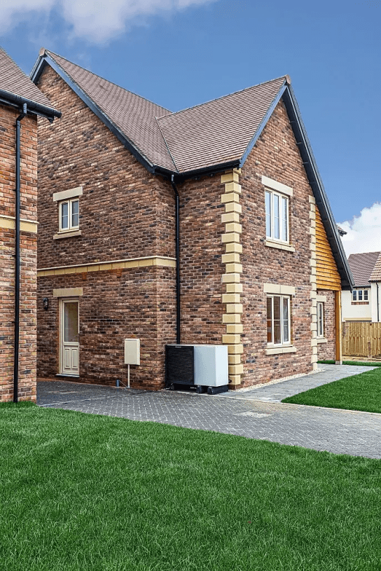 Air source heat pump next to side of house