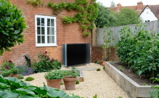 Air source heat pump outside in the garden of a detached home 