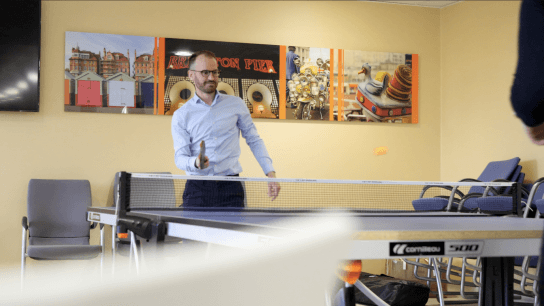 employee playing table tennis in Hove office
