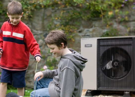 Ideal air source heat pump in the garden with two boys playing in front of it 