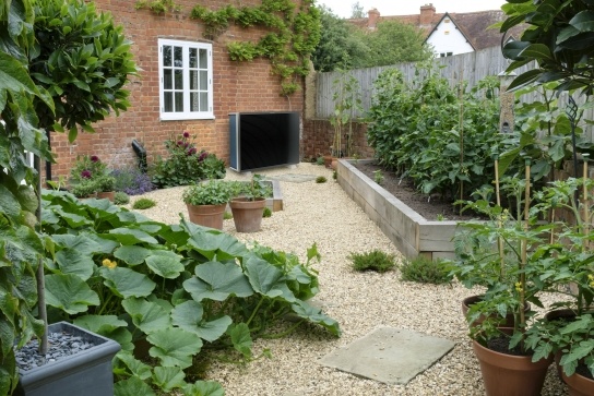 Air source heat pump attached to cottage in a garden