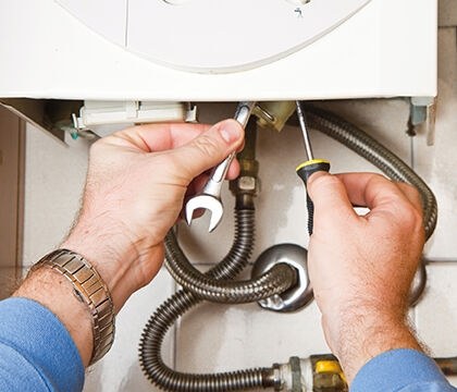 Image showing hands holding tools to fix a boiler