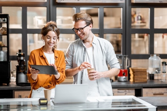 A man and a woman looking at an Ipad