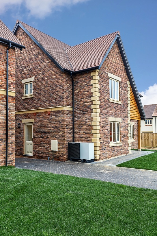 Air source heat pump next to side of house