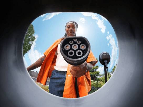 Fisheye lens view of a woman charging a car