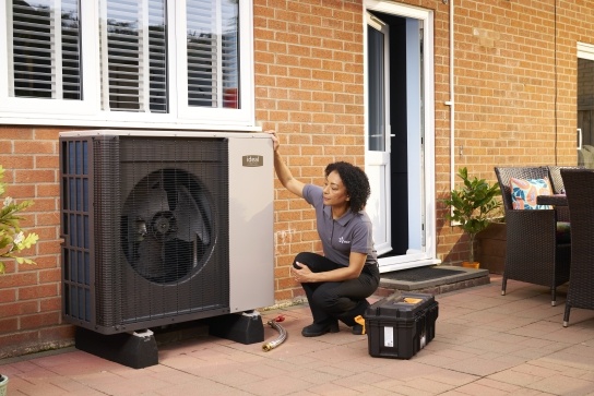 Female air source heat pump installer installing a brand new Ideal heat pump