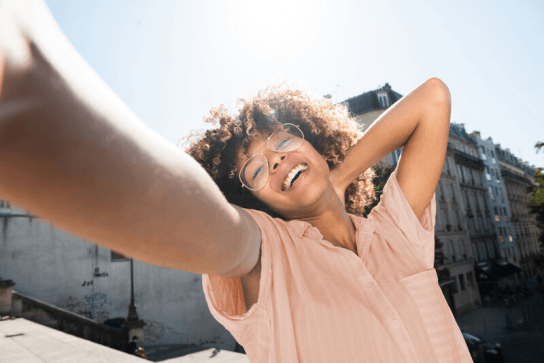 Woman with arm outstretched, in the sunshine