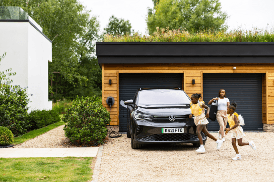 Family outside of a garage with an EV charging