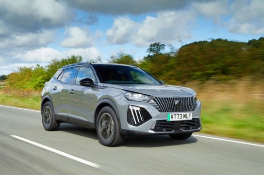 Silver EV SUV cruises through green countryside