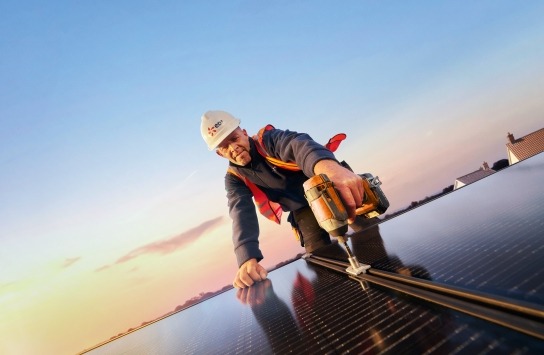 Man on roof installing solar panels